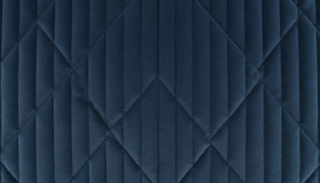 Крупный план текстуры плотного стеганого бархата с высоким, равномерным наполнением, демонстрирующий его матовую глубину и четкость стежки.